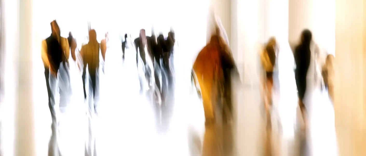 Silhouettes of motion blurred, unrecognizable, business people walking down corridor, a lot of copy space